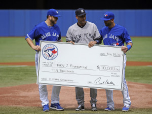 Aug 31, 2014; Toronto, Ontario, CAN;  Toronto Blue Jays players Mark Buehrie (56) and Jose Bautista (19) preset a New York Yankees Derek Jeter (2) check for $10,000 for charity before game at Rogers Centre. Mandatory Credit: Peter Llewellyn-USA TODAY Sports ORG XMIT: USATSI-169386 ORIG FILE ID:  20140831_pjc_lb4_101.JPG
